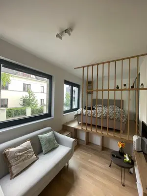a living room with a couch and a large window at Vinice house in Prague