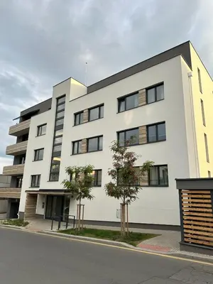 a white building with black windows on a street at Vinice house in Prague
