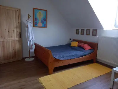 a bedroom with a wooden bed with a blue blanket at Ráj za humny in Černé Voděrady