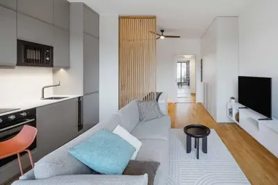 a living room with a couch and a kitchen at Urban Balance Suite, Andel in Prague
