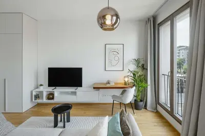 a white living room with a tv and a desk at Urban Balance Suite, Andel in Prague