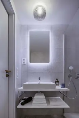 a white bathroom with a sink and a mirror at Urban Balance Suite, Andel in Prague