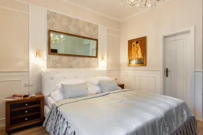 a bedroom with a large bed and a kitchen at Wellness & SPA boutique Hotel pod lipkami Prague in Prague