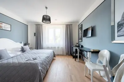 a bedroom with blue walls and a bed and a desk at Wellness & SPA boutique Hotel pod lipkami Prague in Prague