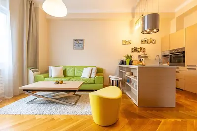 a living room with a green couch and a table at Sunny apartment in Prague