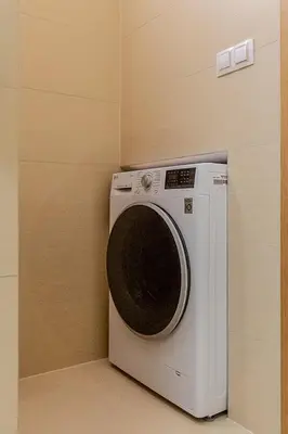 a washing machine in a corner of a room at Sunny apartment in Prague