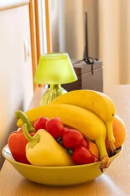 a bowl of bananas and tomatoes on a table at Sunny apartment in Prague
