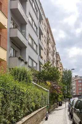 a building with cars parked on the side of a street at Sunny apartment in Prague