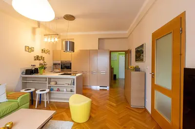 a living room with a couch and a kitchen at Sunny apartment in Prague
