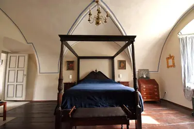 a bedroom with a canopy bed and a chair at Apartment at Château Domoušice in Domoušíce