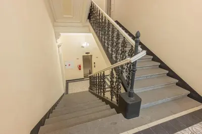 a staircase in a building with a metal railing at HOMELY l 5 min to Airport Express,Train Station with self check in in Prague