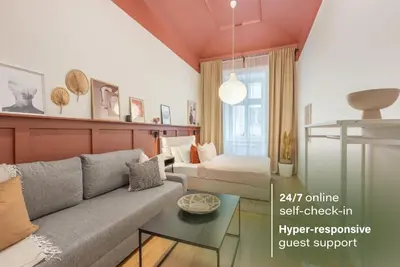 a living room with a couch and a bed at HOMELY l 5 min to Airport Express,Train Station with self check in in Prague