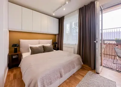 a bedroom with a large bed and a balcony at Modern studio with terrace in Prague