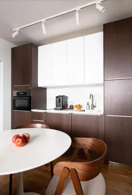 a kitchen with a white table and wooden cabinets at Modern studio with terrace in Prague