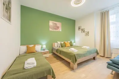 a bedroom with two beds and a green wall at HOMELY I Central 44m2 APT I ELEVATOR I Self Check-In in Prague