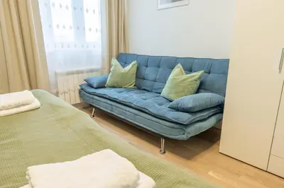 a blue couch in a living room with a mirror at HOMELY I Central 44m2 APT I ELEVATOR I Self Check-In in Prague