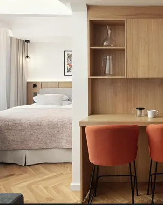 a small kitchen with orange chairs and a bed at Six Residences Prague in Prague