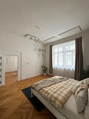a bedroom with a large bed and a large window at City center apartment in Prague