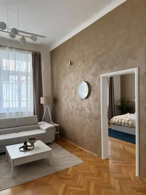 a living room with a couch and a mirror at City center apartment in Prague