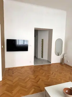 a living room with a television and a wooden floor at City center apartment in Prague
