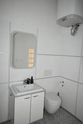 a bathroom with a toilet and a sink and a mirror at City center apartment in Prague