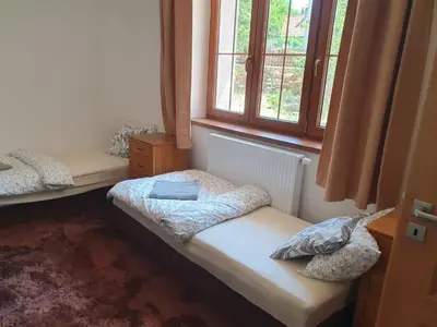 a room with two beds and a window at Statek U Šimla in Lážovice