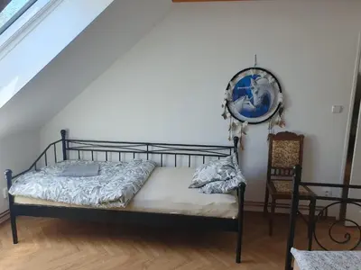 a bedroom with a bed and a chair at Statek U Šimla in Lážovice