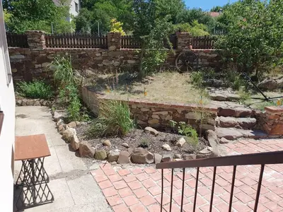 a garden with a stone wall and a fence at Statek U Šimla in Lážovice