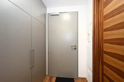 a hallway with a white door and a wooden floor at New Apartment in Heart of Prague in Prague