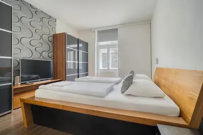 a bedroom with a large bed and a flat screen tv at Botanical Escape Apartment in Prague