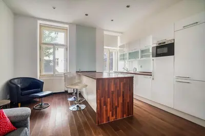 a kitchen with a counter and chairs in a room at Botanical Escape Apartment in Prague