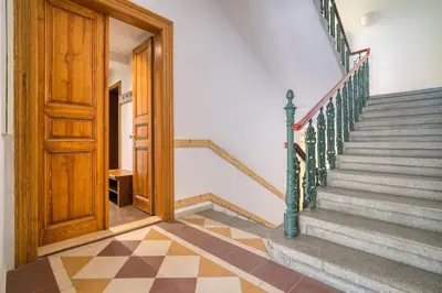 a hallway with stairs and a wooden door at Botanical Escape Apartment in Prague