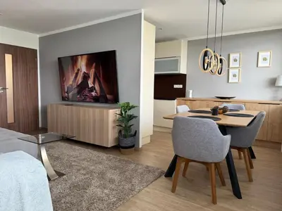 a living room with a table and a tv on a wall at City view Apartment Lenka in Prague