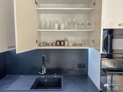 a kitchen with a sink and a shelf with glasses at New Apartment, close Prague center, Free Parking in Prague