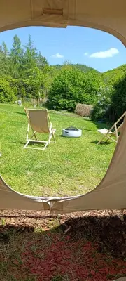 a tent and a chair and a frisbee in the grass at Tee-pee u Honzíka in Zbečno
