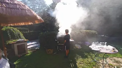 a man standing in a yard with a grill at Tee-pee u Honzíka in Zbečno