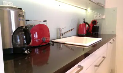 a kitchen with a red appliance on a counter at Veleslavinova - Old Town Apartment in Prague