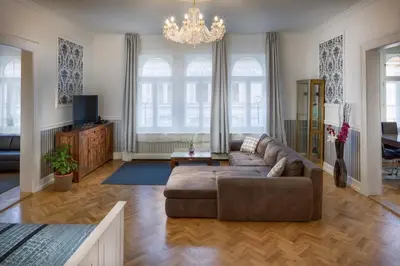 a living room with a couch and a chandelier at Veleslavinova - Old Town Apartment in Prague
