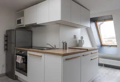 a kitchen with white cabinets and a stainless steel refrigerator at Top Wenceslas Square Apartment in Prague