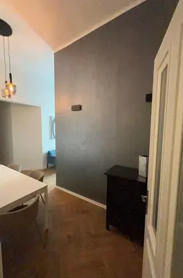 a room with a table and a gray wall at Top Wenceslas Square Apartment in Prague