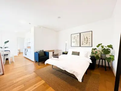 a white bedroom with a bed and a living room at Vila Grebovka in Prague