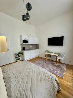 a bedroom with a bed and a table and a tv at Apartment with free garage parking in Prague