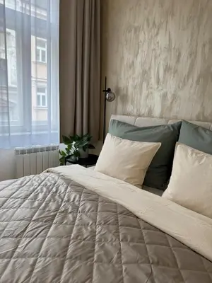 a bedroom with a large bed with pillows and a window at Apartment with free garage parking in Prague