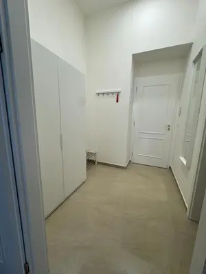 an empty hallway with white walls and a white door at Apartment with free garage parking in Prague