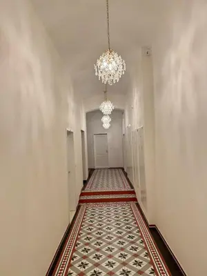 an empty hallway with a chandelier and a carpet at Apartment with free garage parking in Prague