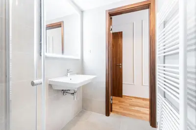 a white bathroom with a sink and a mirror at Rentero Spacious Smíchov 2 Bedroom Apartment with Excellent Tram Connection in Prague