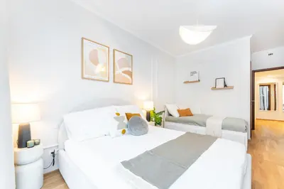 a white bedroom with two beds in it at Rentero Spacious Smíchov 2 Bedroom Apartment with Excellent Tram Connection in Prague