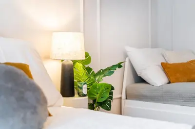 a bedroom with a bed and a lamp and a couch at Rentero Spacious Smíchov 2 Bedroom Apartment with Excellent Tram Connection in Prague
