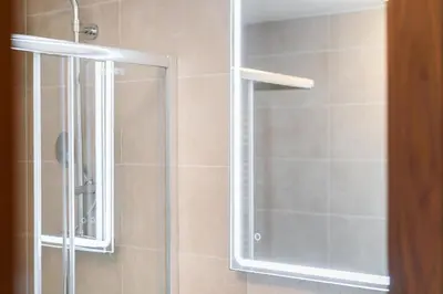 a shower with a glass door in a bathroom at Rentero Spacious Smíchov 2 Bedroom Apartment with Excellent Tram Connection in Prague
