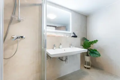 a bathroom with a sink and a shower at Rentero Spacious Smíchov 2 Bedroom Apartment with Excellent Tram Connection in Prague